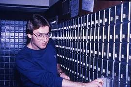 Student opening a mailbox in Douglas Hall.