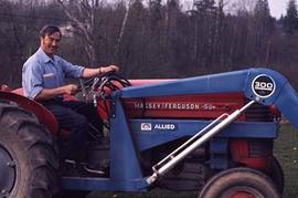 Maintenance staff seated in a tractor on campus.