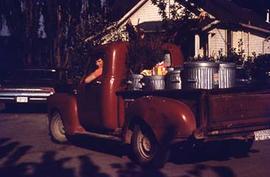 Maintenance staff in a truck with garbage in the back.