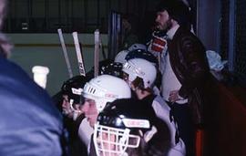 Hockey players on bench waiting to play.