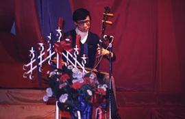 Student playing a stringed instrument during Homecoming.