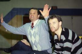 Staff members cheer on a game in the gymnasium.