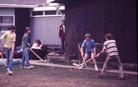 Students playing ball hockey on campus grounds.