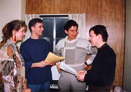 A mixed music ensemble talking in a room