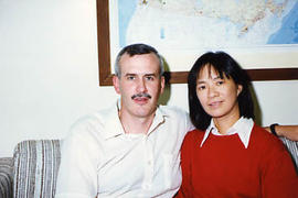 Alumnus seated with his wife on a couch