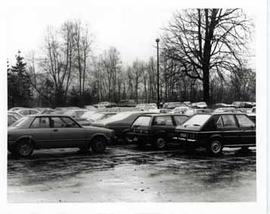 Commuter parking lot full of cars on rainy day