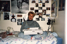 Karen Jonassen sitting on her dormitory bed typing on a typewriter