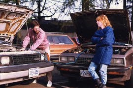 A student helping another student re-charge her car battery