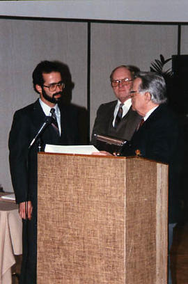 Three men behind the podium at the awards banquet