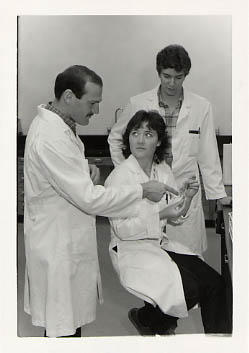 Faculty member talking with students in the lab