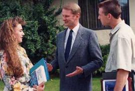 Administrator Don Page chatting with two students on the campus grounds