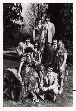 Music group, Selah, posing outside on a log