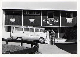 Two female students standing in front of Douglas Hall, which is decorated in "Wild Wild West...