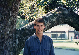 Student posing outside in front of a tree