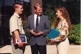 Administrator Don Page chatting with two students