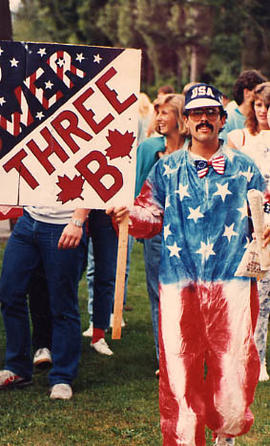 Dwight Piper dressed in costume and holding a dorm sign