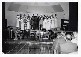 Choir performing on stage in the gym