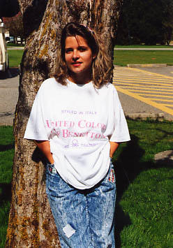 Student standing outside in front of a tree