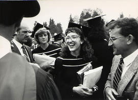 Valedictorian smiling amidst a crowd at the graduation ceremony