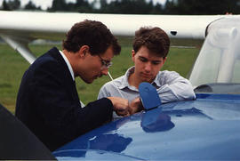 Matthew Edwards and Greg Brown inspecting the tail of a small aircraft