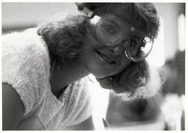 Student smiling while wearing goggles in the lab