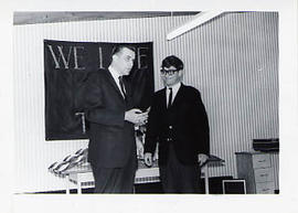 Calvin Hanson handing a trophy to a student