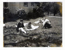 Four male students sitting on the lawn