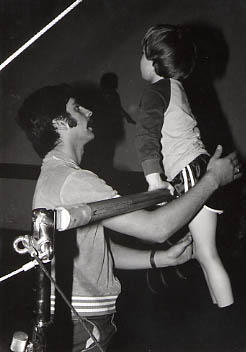 Student working with a boy on the uneven bars