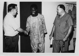 Robert Thompson shaking hands with a Nigerian individual.