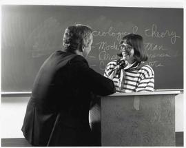 Craig Seaton and Barbara Pell conversing in a classroom