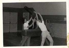 Students working with a gymnast