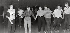 Students rollerskating hand-in-hand