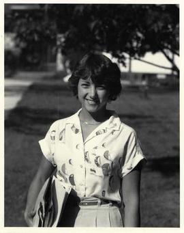 Sandra Wiens standing, smiling, on campus grounds