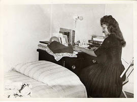 Student seated at a desk in her dorm room