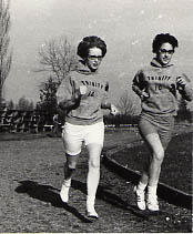 Two female track and field members running