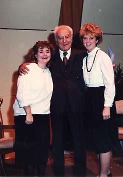 Speaker posing with two students