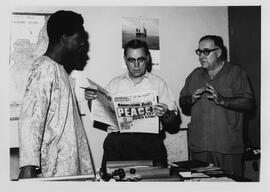 Robert Thompson reading the Benin newspaper on assignment during the Biafran Civil War.